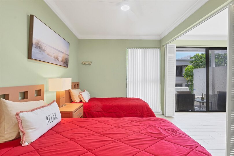 Guest bedroom features 2 twin beds, 32-inch Smart TV and attached bathroom