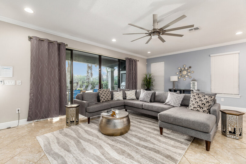 The living area has a comfortable seating for all with a beautiful pool view