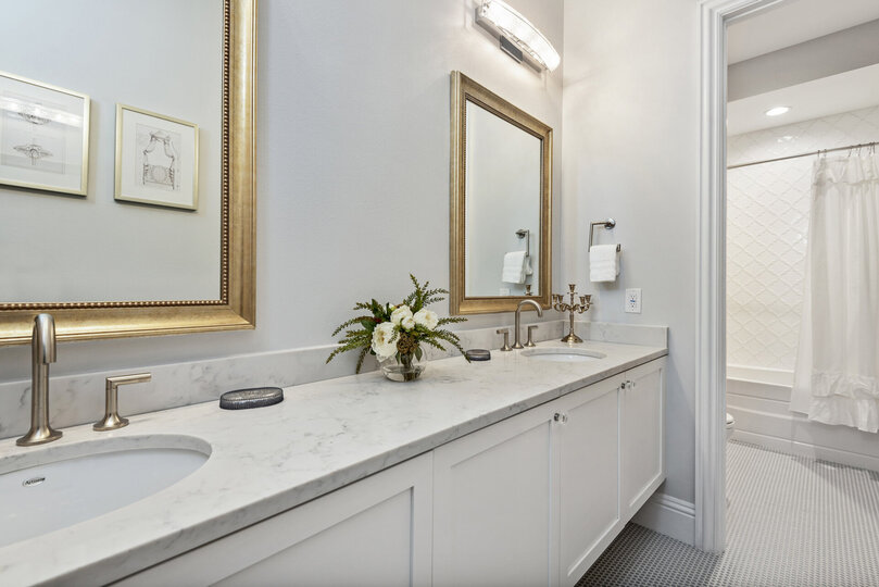 The connected bathroom has a dual vanity