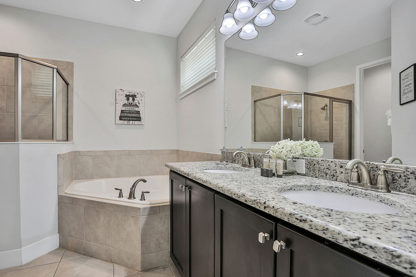 Master bathroom on the ground floor with dual vanity, garden tub, and walk-in shower