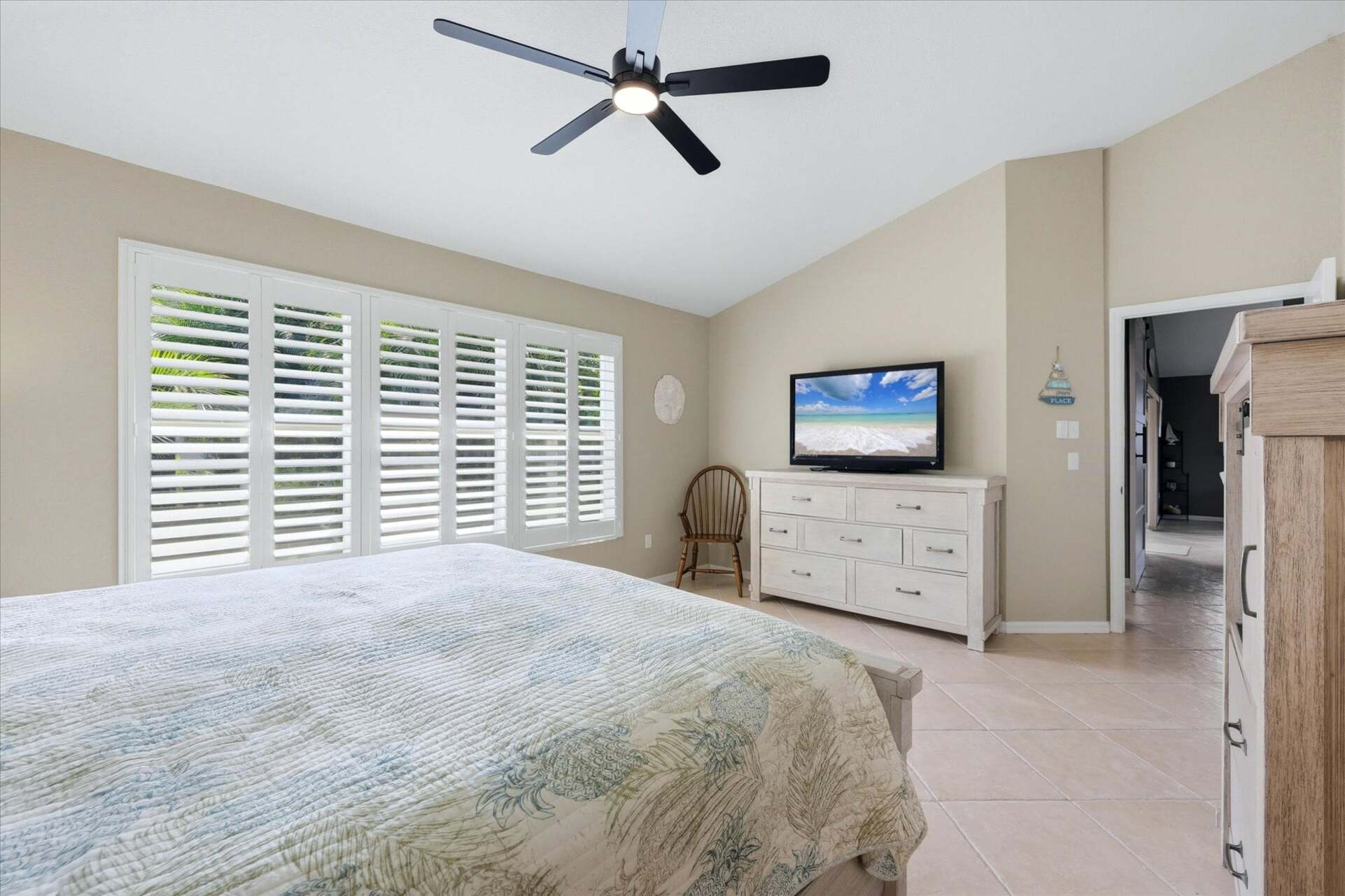 Primary bedroom with king bed, attached bathroom, and 46-inch smart TV