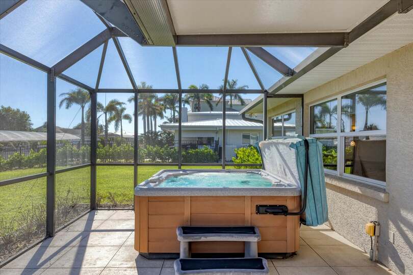 Screened-in patio overlooking the canal with private hot tub that seats 6 and outdoor dining area