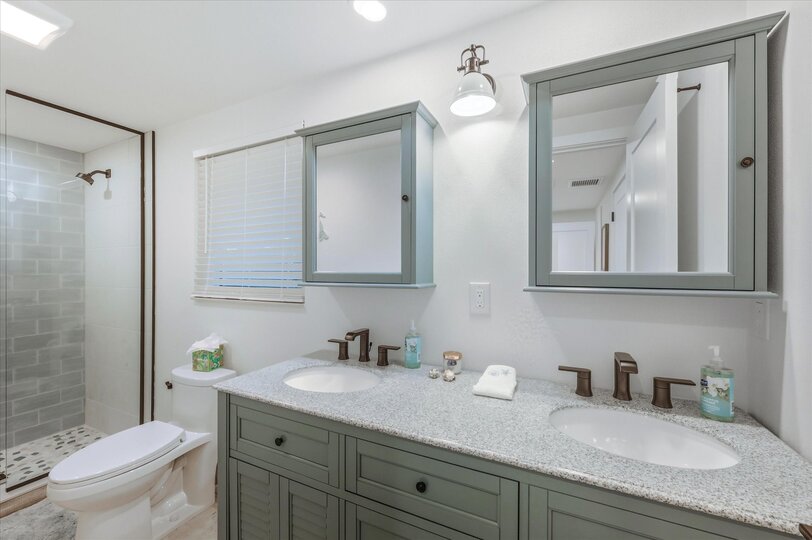 Bedroom 1's attached bathroom with walk-in shower and double vanities