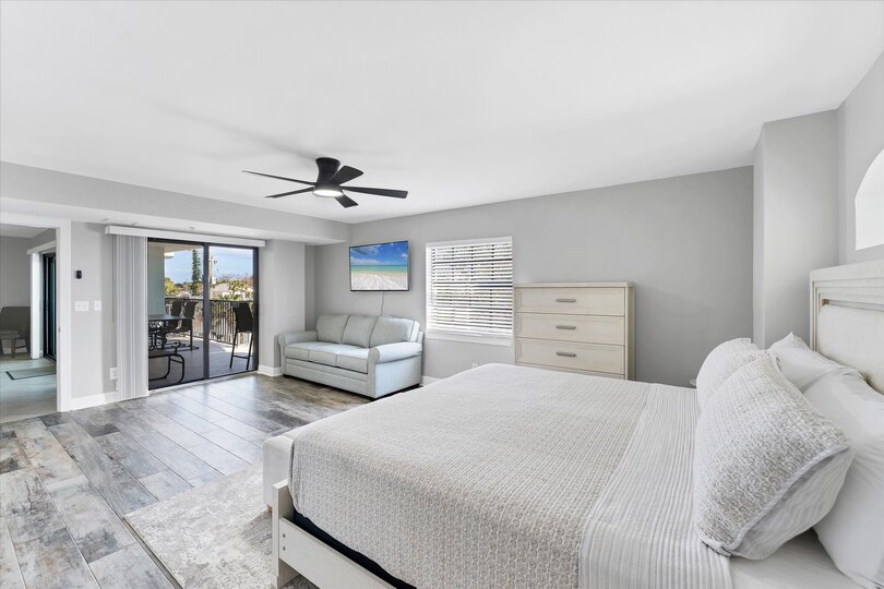 Primary Bedroom With King Bed,  attached bathroom, 50-inch Smart TV, and balcony access